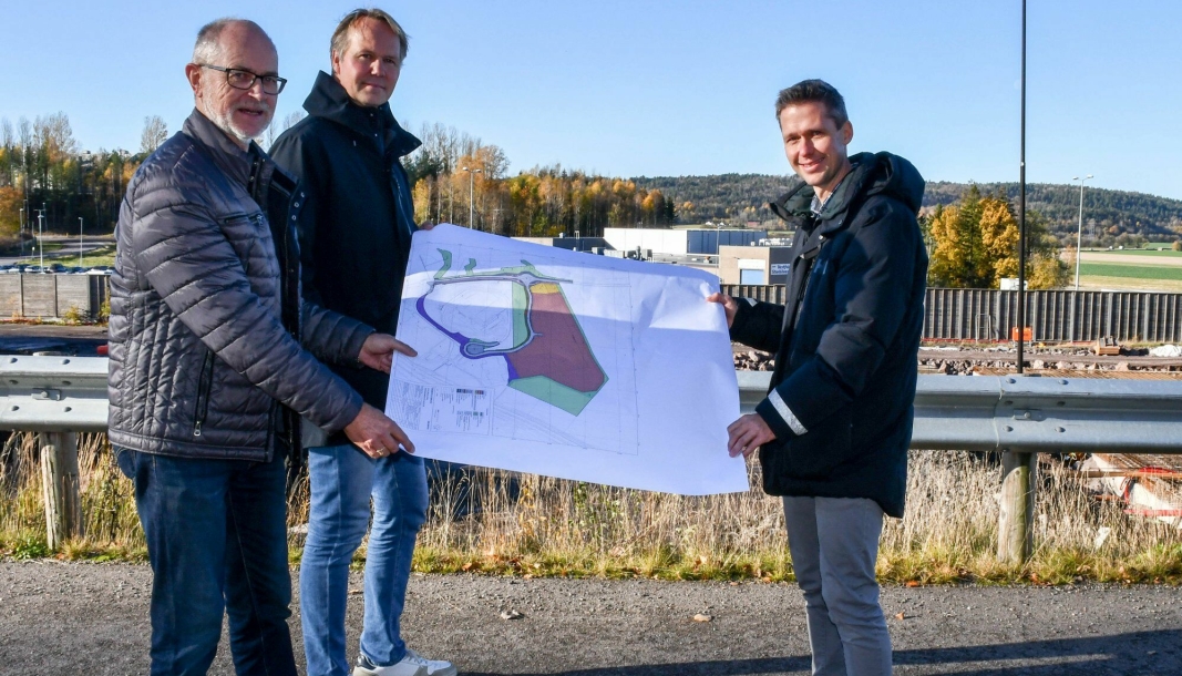 Fra venstre: Sigbjørn Myhre, Espen Karlsen og Andreas Olsen skal sammen bygge Norges største frittstående fryselager på Åskollen Næringsmiddelpark. Hele området ser vi avmerket på kartet, og i bakgrunnen på bildet. (Foto: Aleksander Limkjær)