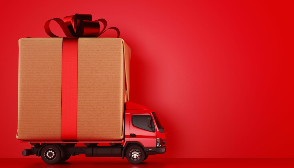 Delivery of a large gift box for Xmas on a red background